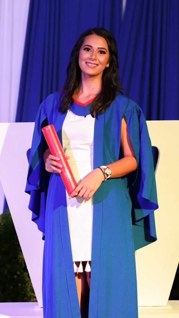 a woman in a blue and white dress holding a red object